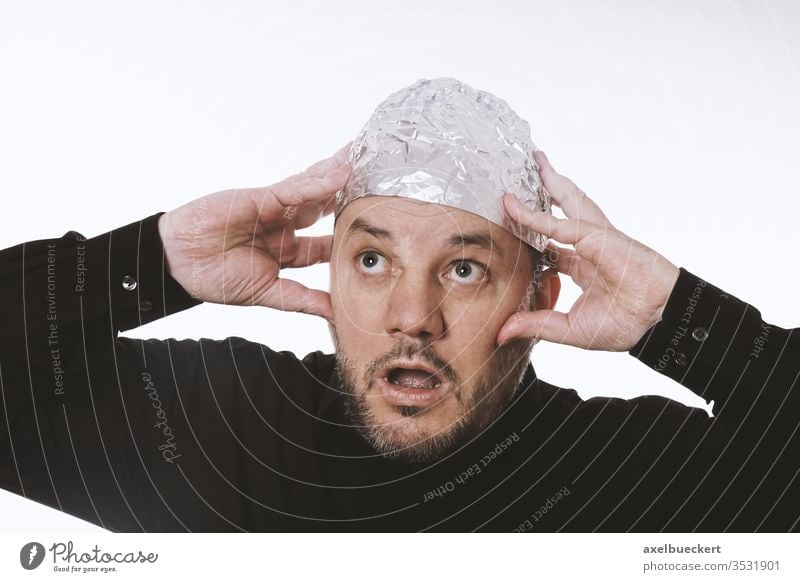 paranoid man wearing tin foil hat conspiracy theory aluminium mind control paranoia tinfoil cap helmet protection telepathy hum 5G scared shield strange