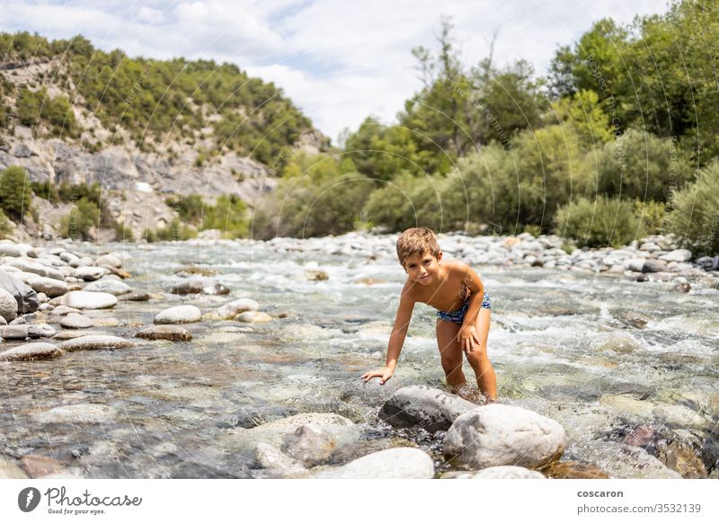 Little child in the middle of a wild river activity alone cheerful childhood cinca coast crossing day enjoyment flow fun game girl happiness healthy holidays