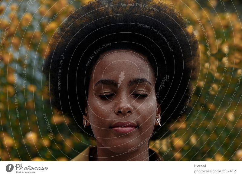 thoughtful afro woman with closed eyes in a garden black woman girl dreamer young people portrait lifestyle cool lovely yellow flower outdoor exterior nature