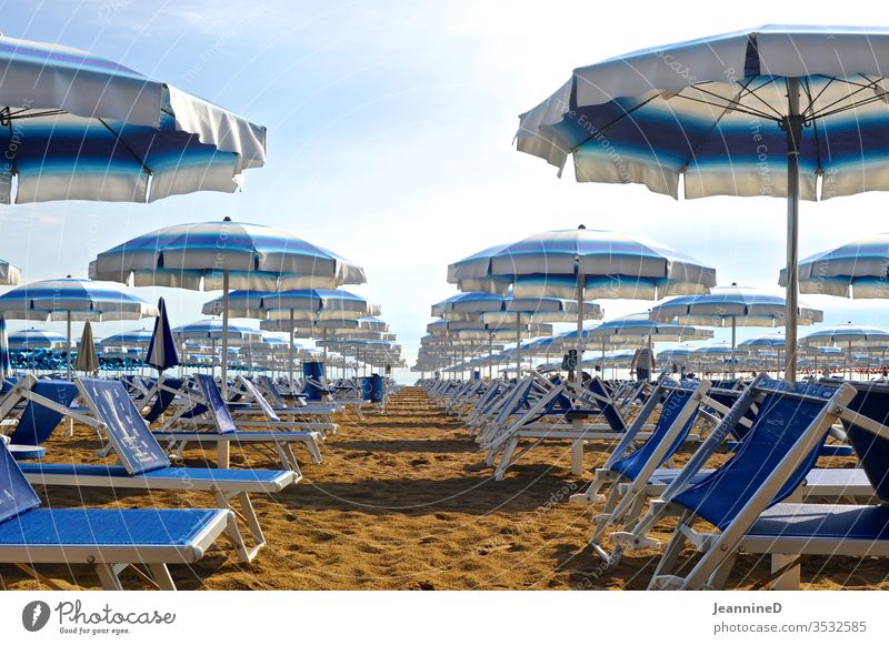 blue sunbeds with matching umbrellas on the beach - a Royalty Free ...