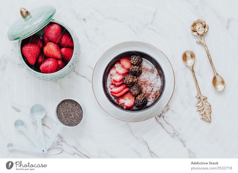Delicious dessert with fresh berries with cinnamon in arrangement with decorative golden spoons on table breakfast yogurt bowl blackberry healthy food smoothie