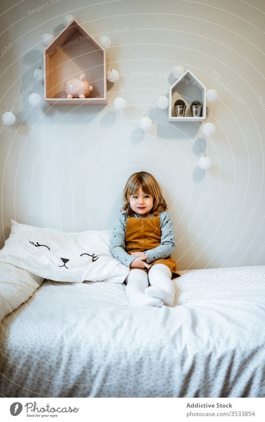 Cute girl looking at camera home cozy rest cute casual calm portrait little outfit adorable kid room childhood relax innocent domestic blond harmony tranquil