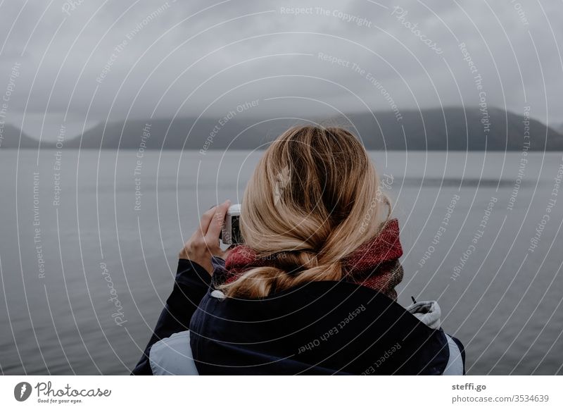 Woman photographs seascape in Scotland with a camera Great Britain Europe Bad weather Fog Lake Loch Ness Nessi Nessie Nature Landscape Clouds Colour photo