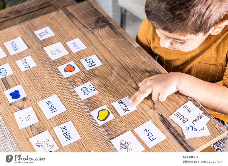 Little kid playing with cards of words and pictures. alphabet back to school boy cartoon childhood children classroom concentrate coronavirus education