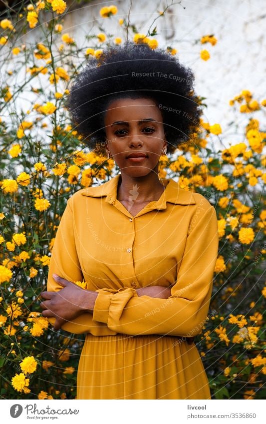 young african american woman in yellow dress enjoying a garden with yellow flowers black woman girl people portrait lifestyle cool lovely outdoor exterior