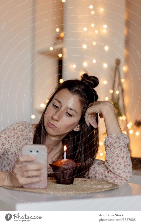 Disappointed birthday woman browsing smartphone at home during COVID 19 disappoint covid 19 quarantine celebrate alone unhappy female upset coronavirus pandemic