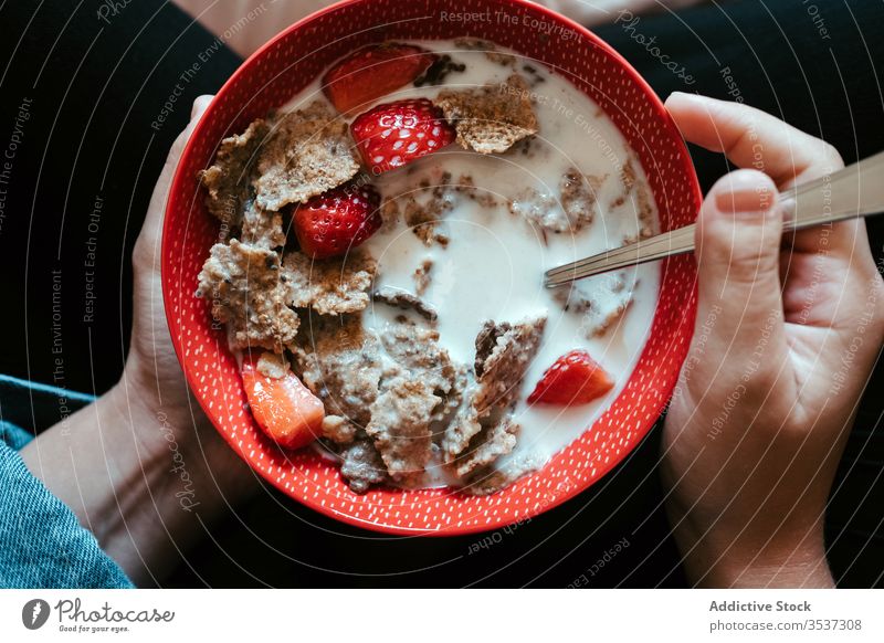 Woman eating dairy mix of strawberry and oatmeal at home woman milk hand bowl food diet healthy red female taste liquid breakfast cereal nutrition fresh piece