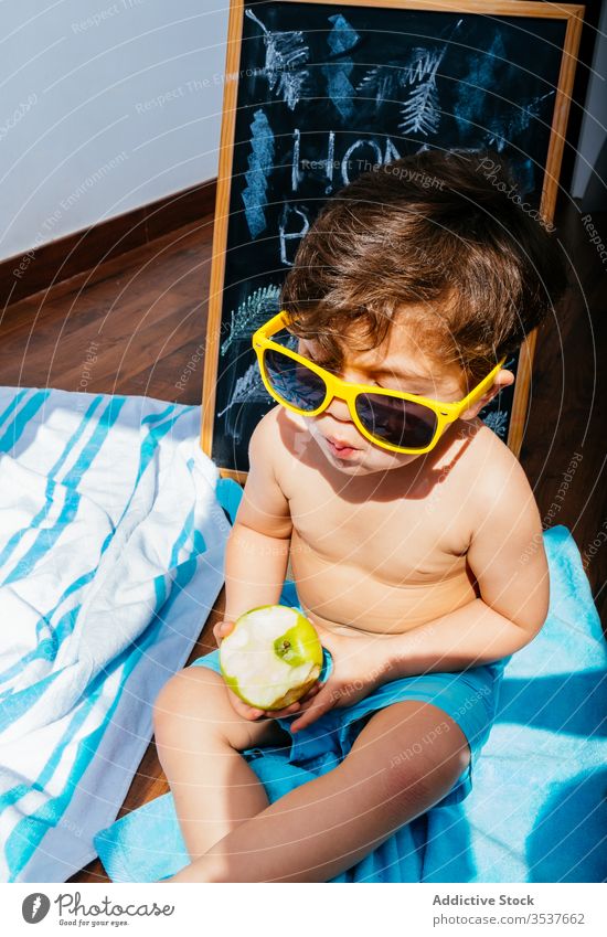 Happy little boy in sunglasses having beach at home dreaming of summer self isolation fun happy social distancing quarantine cheerful yellow blue playful