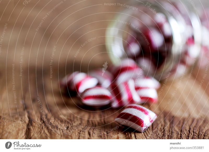striped candy Food Nutrition Eating Red White Candy Shallow depth of field Glass Wooden table Delicious Calorie Lick Stripe Striped Tasty Sense of taste