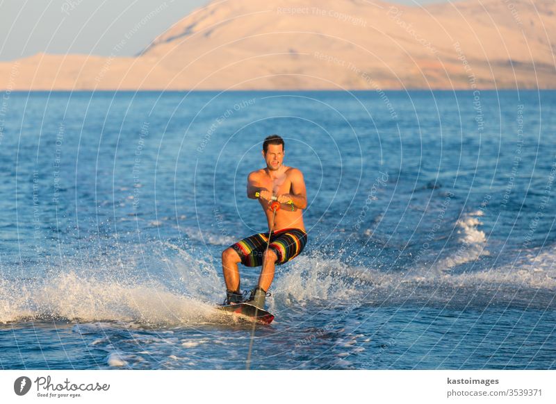 Wakeboarder in sunset. wakeboard sport man extreme wakeboarding sea wave cable fun water recreation splash young male action summer person outdoor wakeboarder