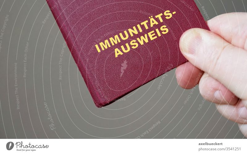 german immunity pass or passport - hand holding mock-up european immune certificate travel document corona coronavirus covid-19 germany immunization pandemic