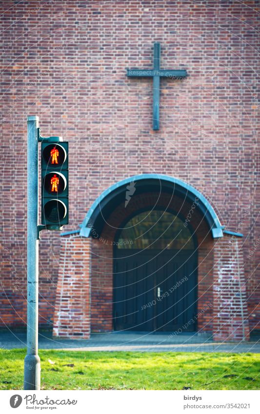 Red pedestrian light in front of the entrance of a church Church leaving the church Crucifix red traffic light Religion and faith Deserted Christian cross