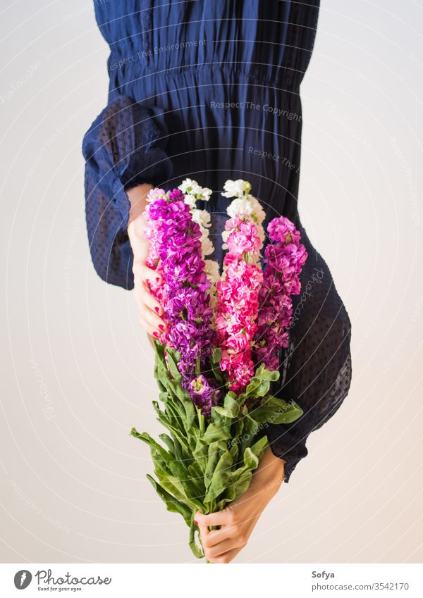 Creative female faceless portrait with bunch of flowers pink mothers day woman spring matthiola incana purple romantic bouquet womens day gift trendy dark dress