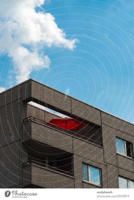 The red parasol on the balcony on the apartment block architecture balconies Berlin blue building building exterior cement city clean cloud clouds concept day