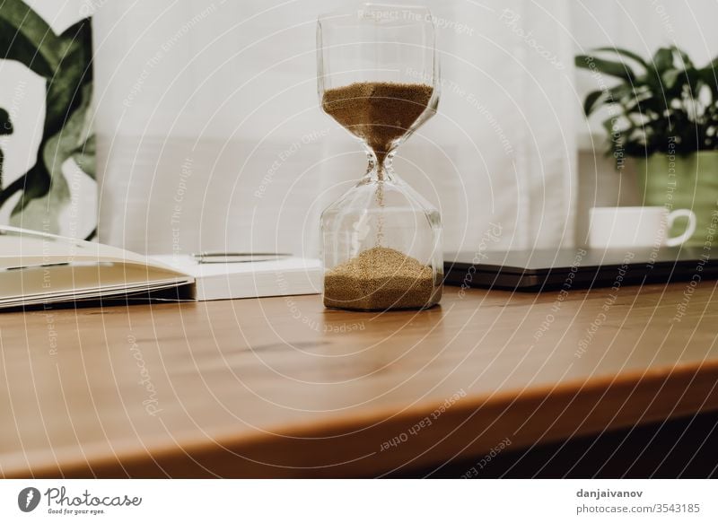 hourglass on a wooden table time sand clock timer isolated white sandglass antique countdown object watch old sand-glass minute past instrument retro deadline