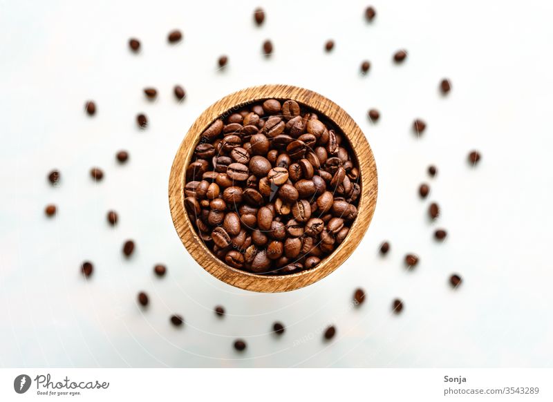 Top view of whole roasted beans in a wooden bowl, close-up Coffee bean entirely Beans Aromatic Brown Sense of taste Close-up Breakfast Food Caffeine natural