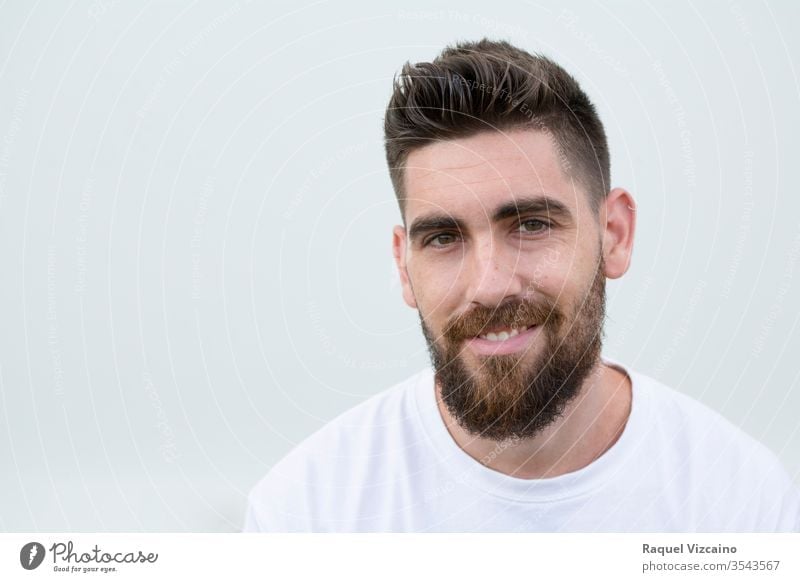 Portrait Of A Very Handsome Caucasian Smiling And Happy Man With A Beard And White Shirt A 