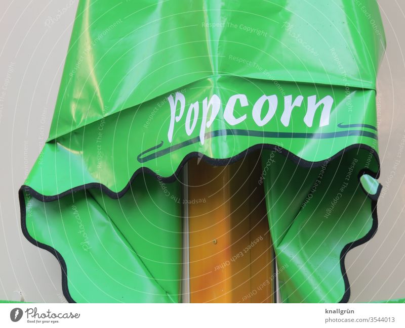 Advertising for popcorn on green lacquer foil Characters Letters (alphabet) Word Typography Signs and labeling Signage Exterior shot Colour photo White