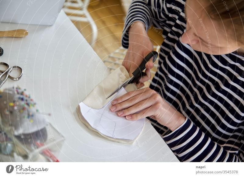 Brave little tailor | Young woman cuts a piece of fabric at her sewing table with the help of a pattern. Sewing Tailoring Handcrafts Cloth sewing accessories