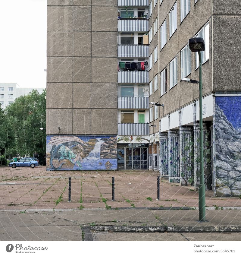 Panel building with courtyard, pavement, paintings and lantern Prefab construction Facade Apartment Building Berlin Lichtenberg Blue mural painting Lantern off