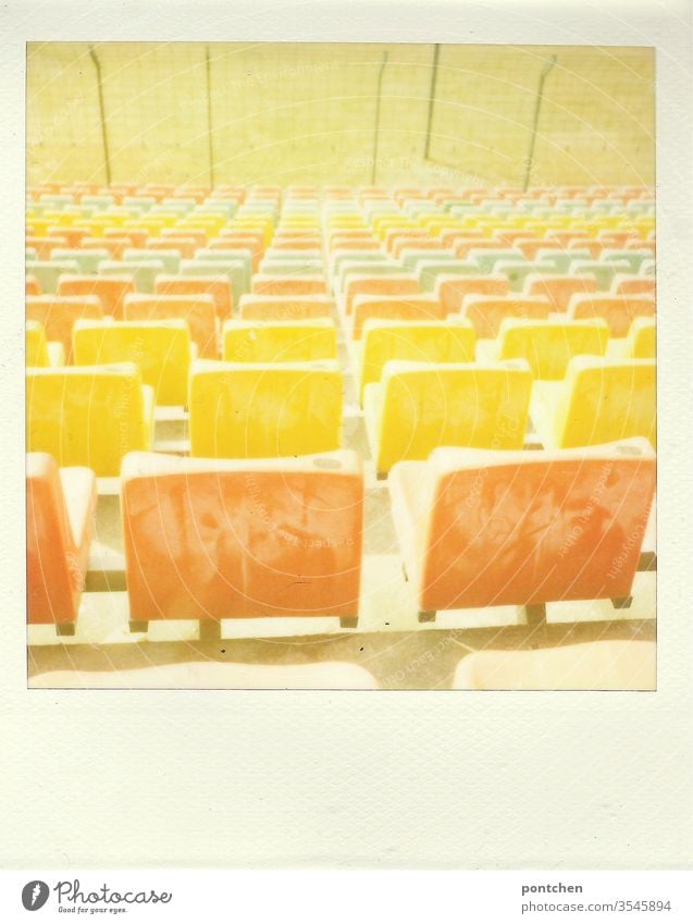 Polaroid. Colorful seats in a stadium. Sports facility, football. Turf Stadium variegated Orange Yellow green Lawn soccer Old Past Grating cordon Architecture