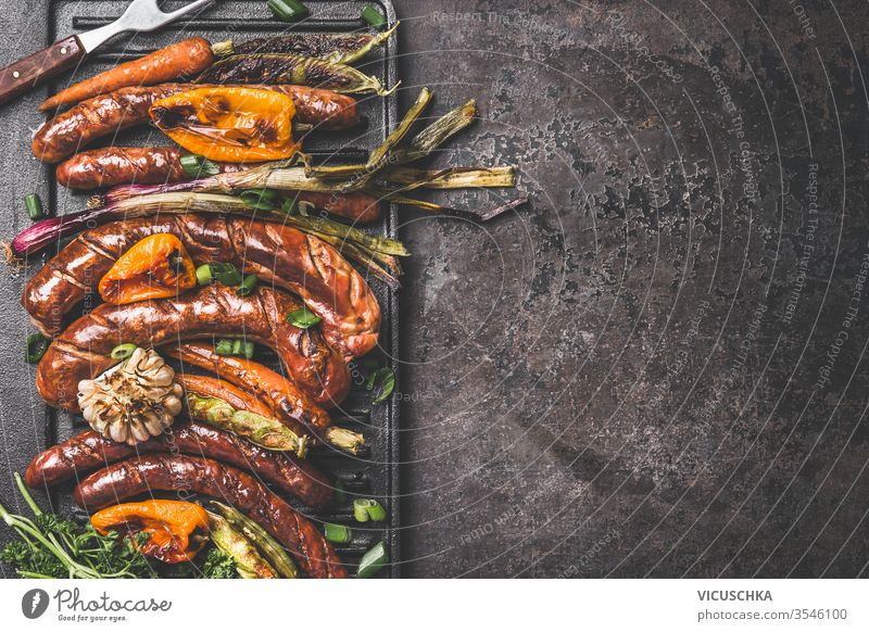 Dark roast food background with grilled sausages and roasted vegetables. Top view. Barbecue grill party plate. dark top view barbecue copy space design product