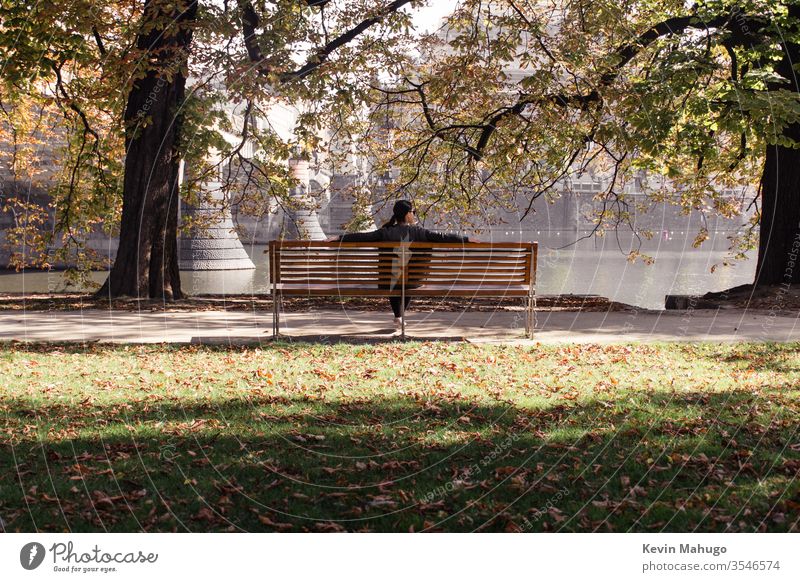 Woman with river in front of her while sitting on a park bench - a Royalty  Free Stock Photo from Photocase