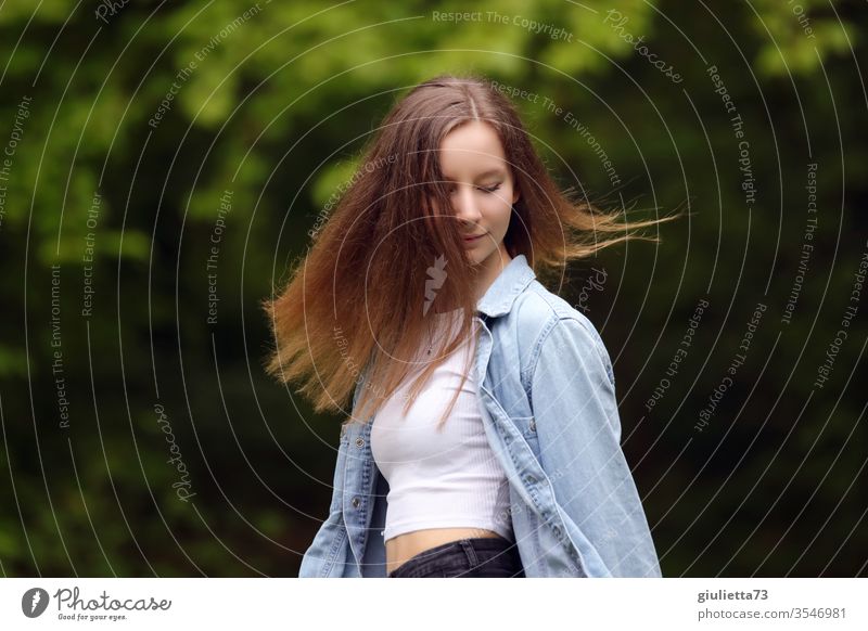 Portrait of a pretty cheerful young woman, teenager with long hair, in the park Half-profile Looking away portrait Motion blur Shadow Light Day Exterior shot