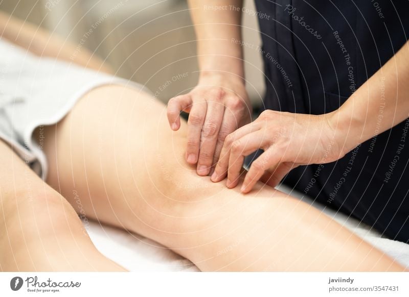 Physiotherapist woman doing a treatment on a woman's knee. physiotherapy leg chiropractor physical physiotherapist patient rehab clinic care health shoulder