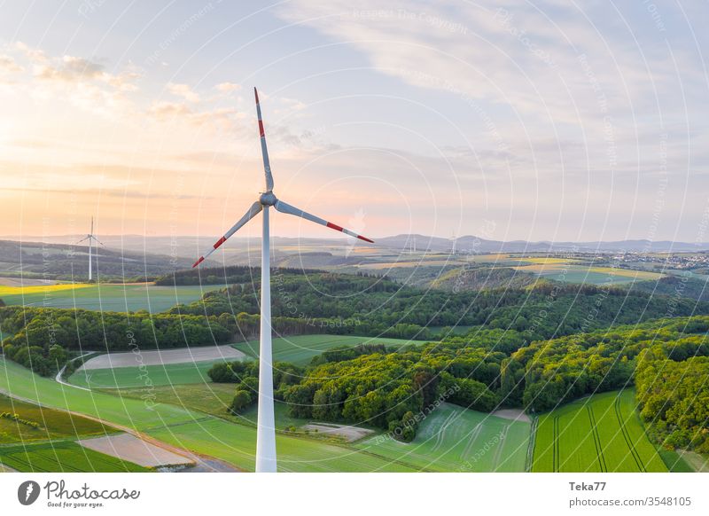 wind wheel on a lush evening landscape air electricity energy forest hills from above green electricity green energy needle forest panorama turbine some
