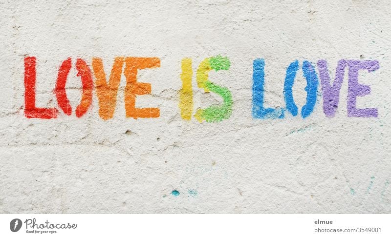 "Love is love" in print and in rainbow colours on grey plaster wall love is love LGBT Prismatic colors Tolerant same sex homosexual Equality heterosexual