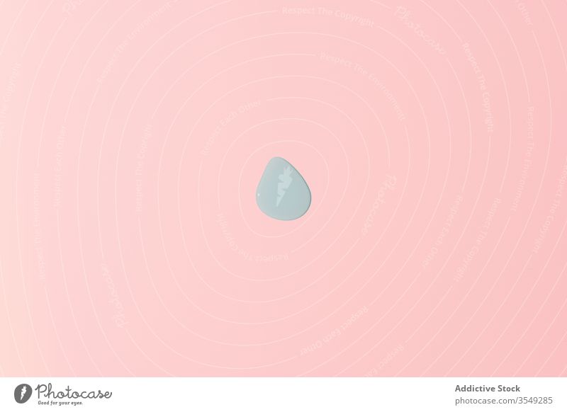 Blue water drop located in the center on pink background symmetry simple minimal droplet aqua abstract motif smooth similar template geometry shape blue concept