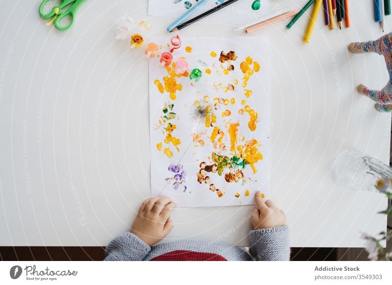 Focused blond child using gouache for finger painting at home boy draw creative kindergarten stick drawing paper little cute adorable childhood preschool hobby