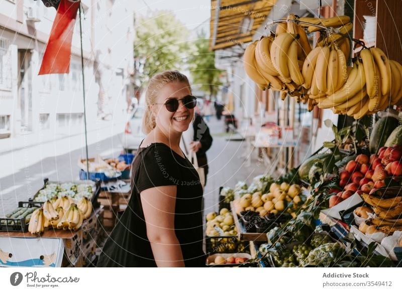 Woman choosing fruits in local market woman counter bazaar street colorful choose goods explore walk city lifestyle buyer shopper sunglasses outdoors customer