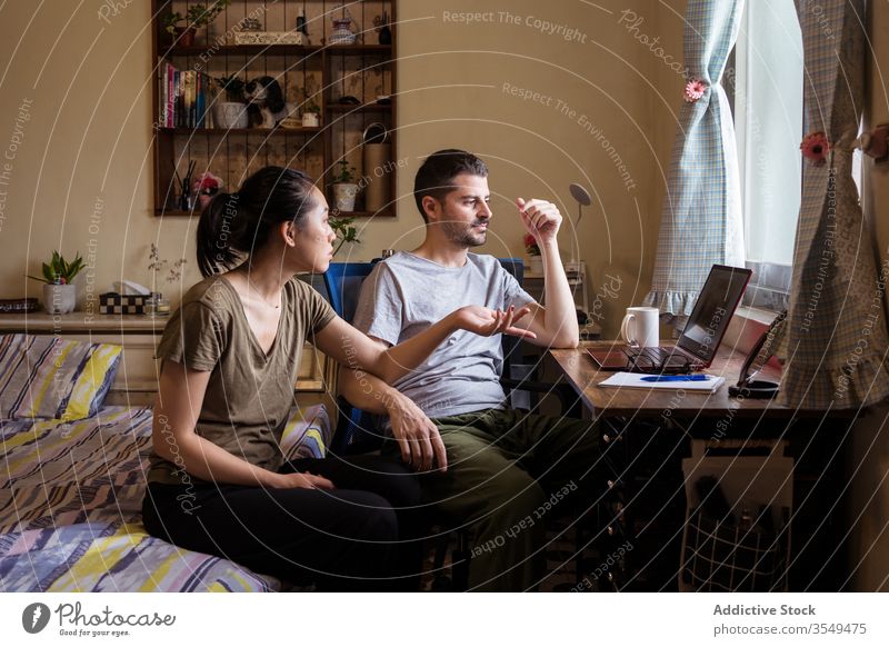 Multiethnic couple in love watching movie on laptop bedroom together discuss video using multiracial multiethnic diverse asian young casual outfit apparel wear
