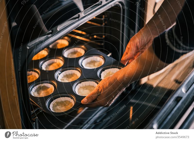 Elderly woman baking muffins in oven at home tray bake elderly cook muffin case dough bakery female aged senior kitchen homemade domestic product housewife lady