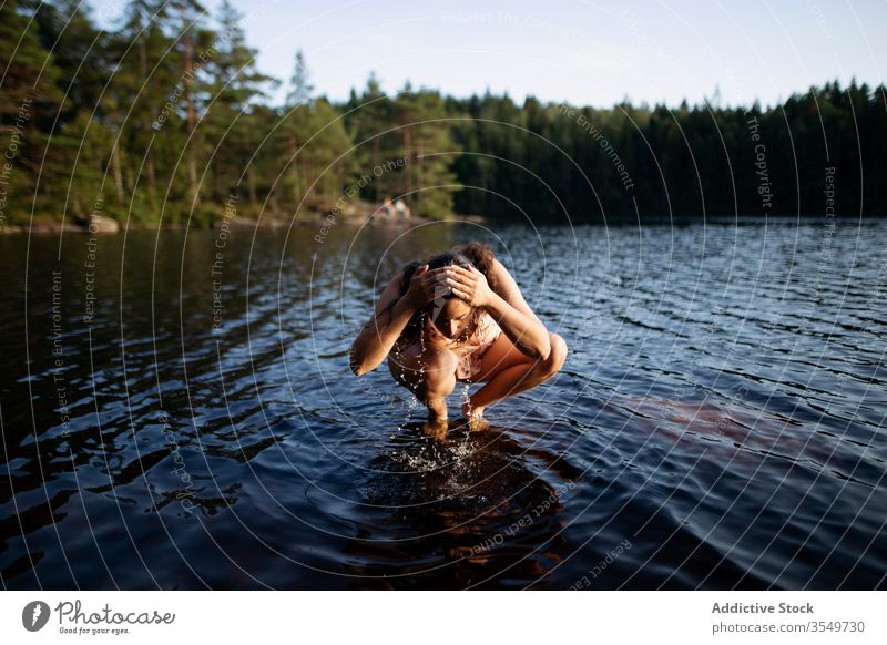 Woman washing face in river during summer vacation woman forest sunset majestic landscape water female barefoot tranquil calm ripple harmony peaceful idyllic