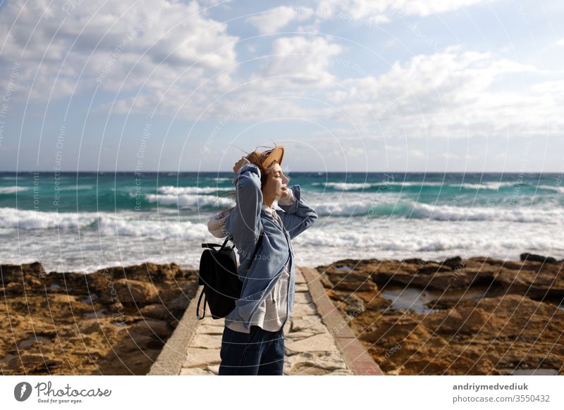 female traveler admiring a marine view. tourism in Cyprus. tourist on sea background. girl travels on the beaches. young beautiful hipster woman on tropical beach, summer vacation, happy, fun,