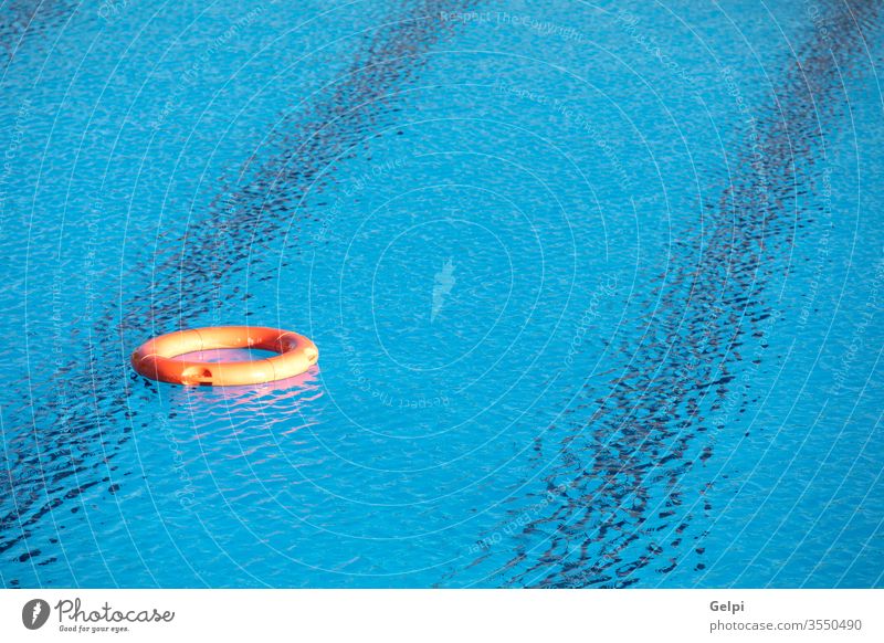 Orange lifebuoy floating on a pool rescue save lifeguard equipment water security lifestyle summer sunny blue protection lifebelt emergency safety swim help