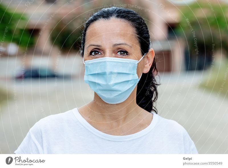 Brunette woman wearing a mask protection street face outdoor corona healthcare Covid-19 coronavirus influenza city pandemic girl medical epidemic people