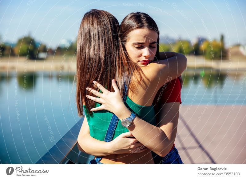 Young woman hugging and supporting her best female friend beautiful people water caucasian person young sadness loneliness pretty embrace nature love beauty