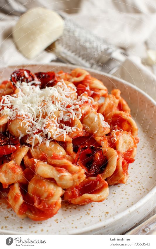 South italian  pasta orecchiette with tomato sauce and cacioricotta cheese apulia tomatoes sugo close up white wooden cooked cuisine diet dinner dish food