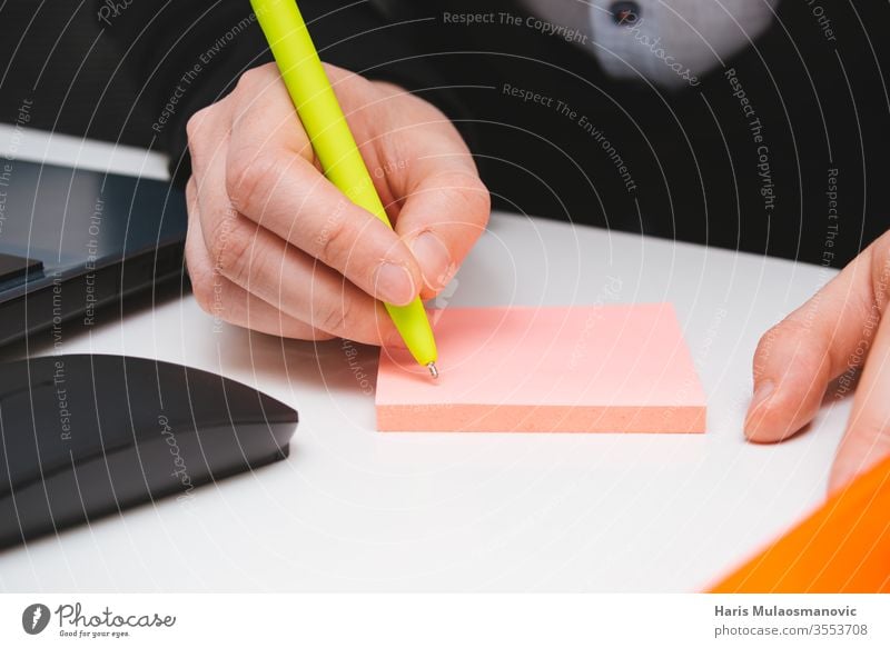 Hand writing with pen on the pink sticker note in the office close up adult background board building business closeup colors computer concept crayons design