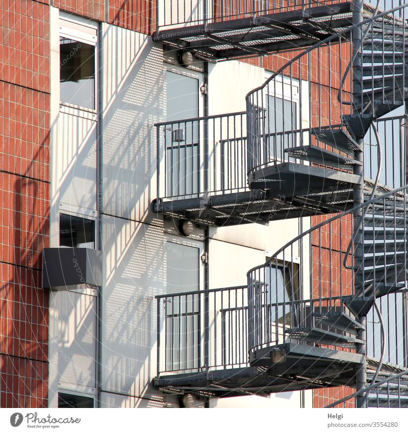 Metal staircase on a facade with light and shadow Facade Wall (building) Stairs Metal steps stair treads Handrail Window door Light Shadow Wall (barrier)