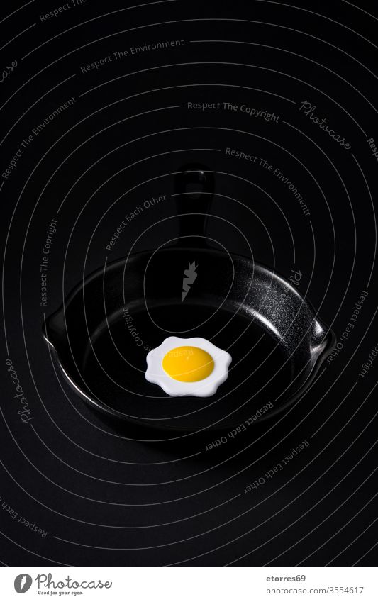 Black frying pan with egg inside on black background concept crockery dried empty food iron isolated kitchen minimalism mockup object slate white yolk