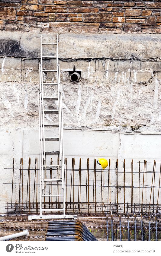 Construction site with aluminium ladder, reinforcing iron and yellow helmet Helmet Colour photo Work and employment Workwear Safety reinforcing irons