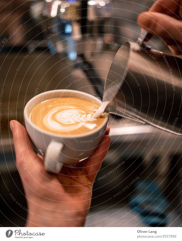 Milk is being poured from the milk jug into espresso in a coffee cup to make latte art Latte Barista Coffee Coffee house Coffee shop Caffeine Latte art
