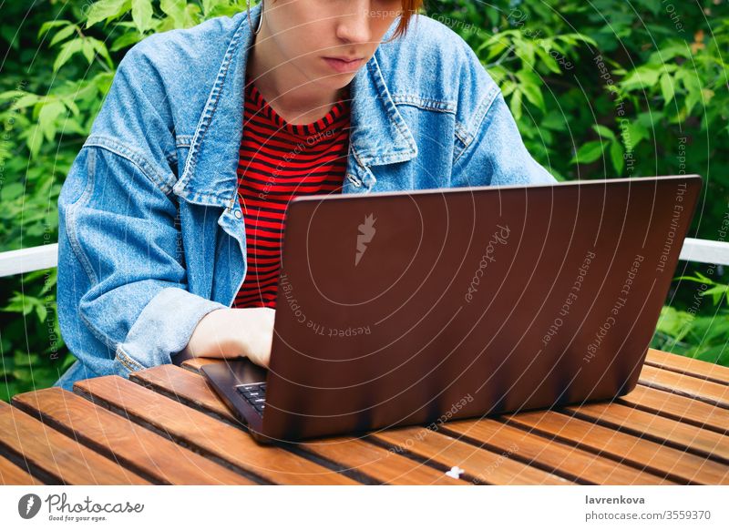 Closeup portrait of young adult female freelancer working on her laptop outside student online job sitting woman outdoor internet communication person lifestyle