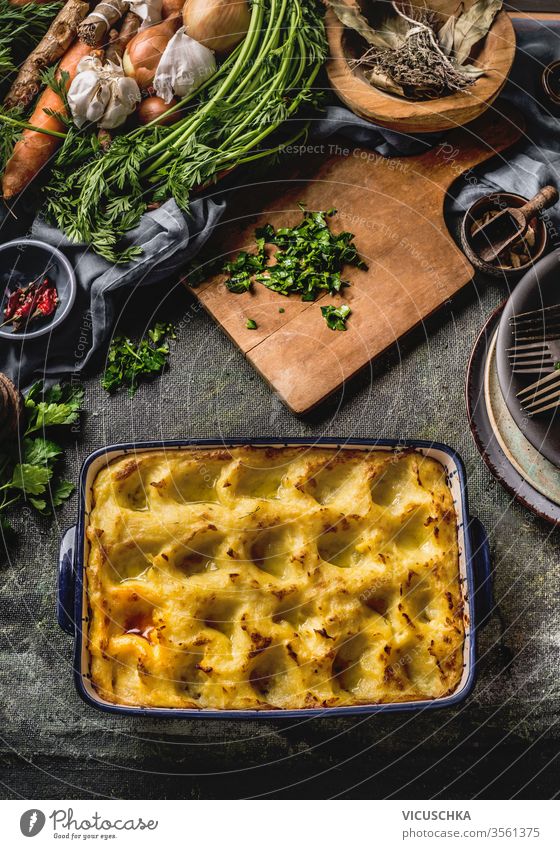 Potato casserole . Homemade cooking. Chopped greens on wooden cutting board. Various vegetables and herbs. Top view. Tasty home cuisine potato homemade farm