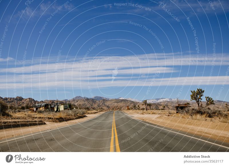 Empty highway on rocky countryside road road trip route desert asphalt sand dry heat mountain picturesque nature valley calm range freedom usa sky california